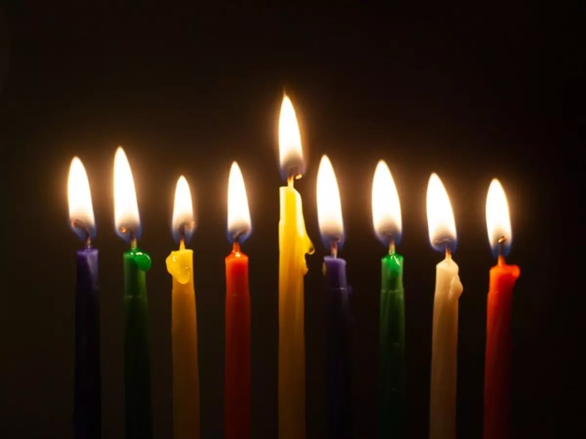 Várias velas coloridas alinhadas, prontas para um ritual.